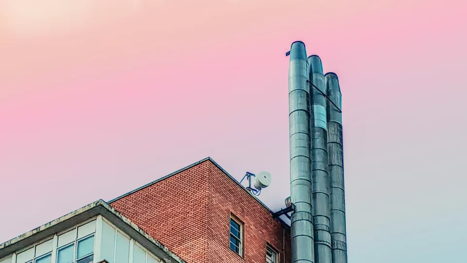 Industry building with pink sky behind. Photo. 