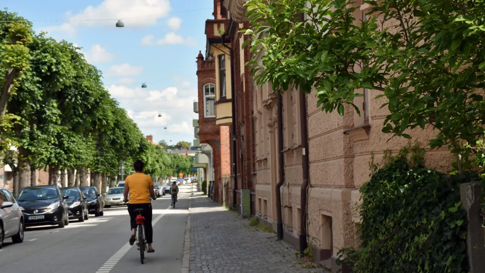 Street view from Lund where it's summer and someone is biking. Photo. 