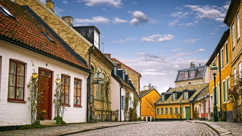 Old street in Lund with colourful houses and blue sky. Photo. 