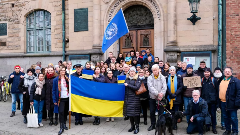 People standing in front of the IIIEE building holding the ukrainian flag. Photo. 