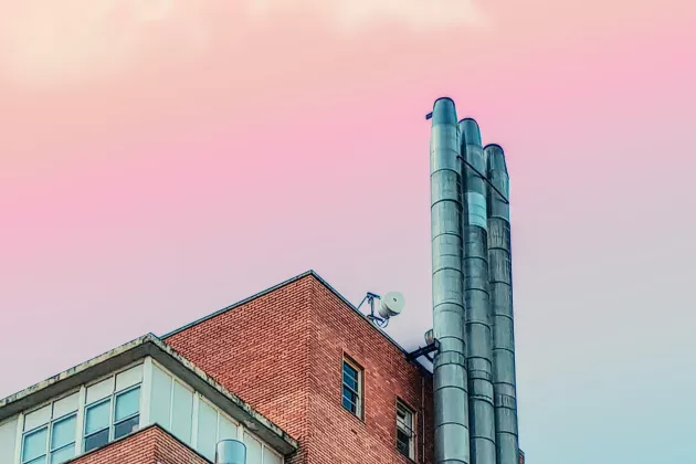 Industry building with pink sky behind. Photo. 