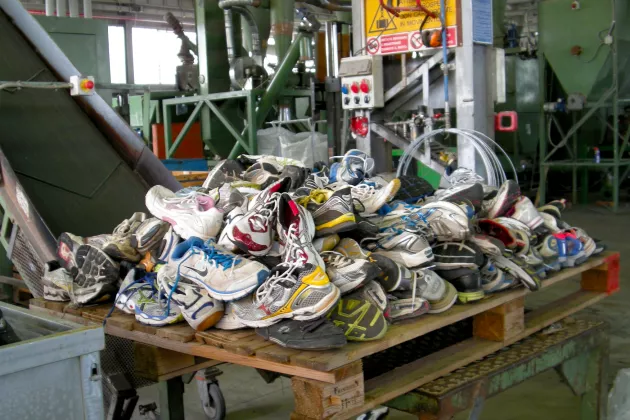 scrapped shoes in a pile in a factory