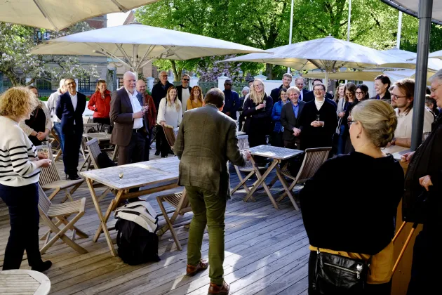 Crowd outdoors listening to someone giving a speech