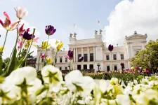 White university building with flowers in the foreground