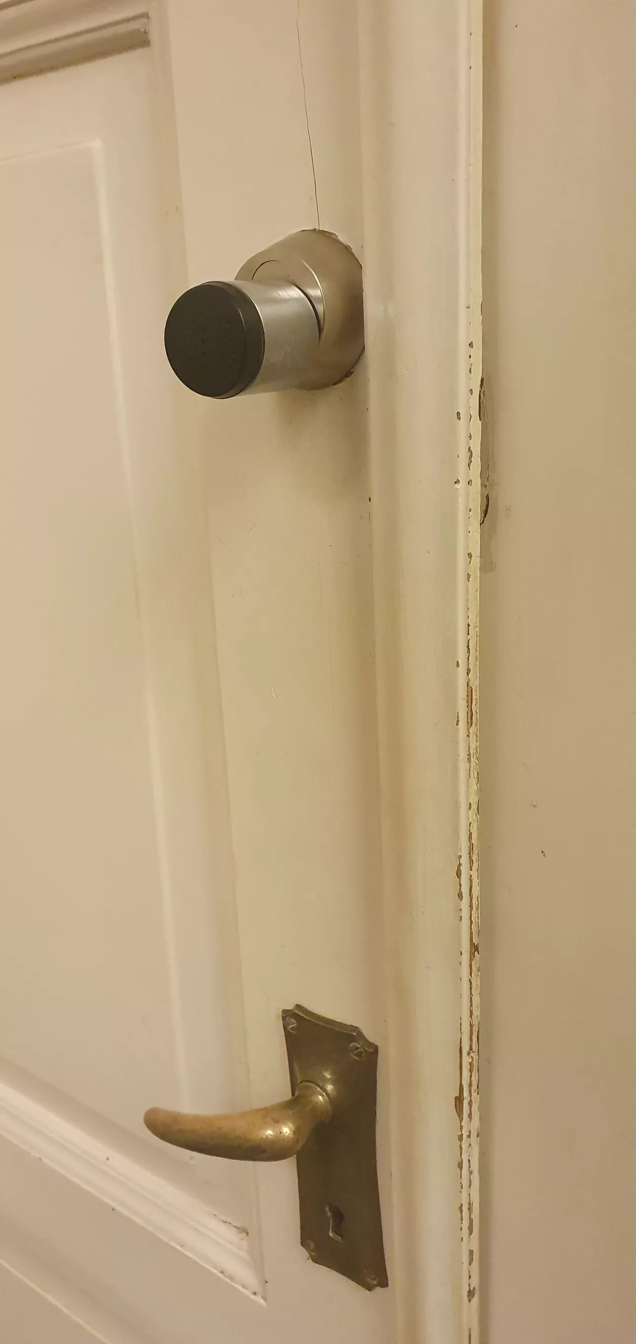 wooden door with a round black card reader above the door handle