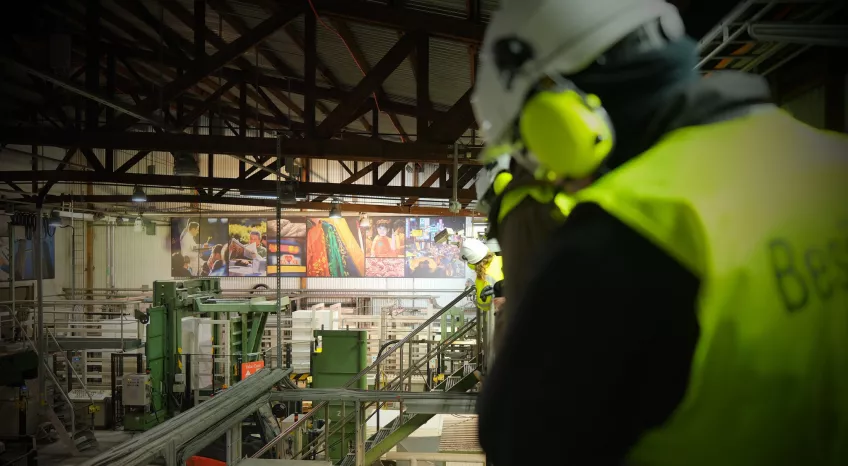 Person in yellow vest at a factory