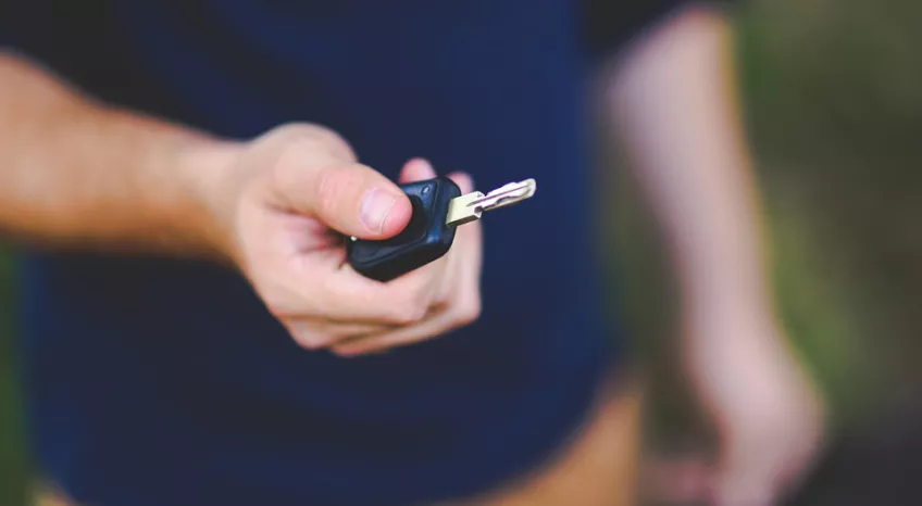 Extreme close up of a man's hand holding a car key 
