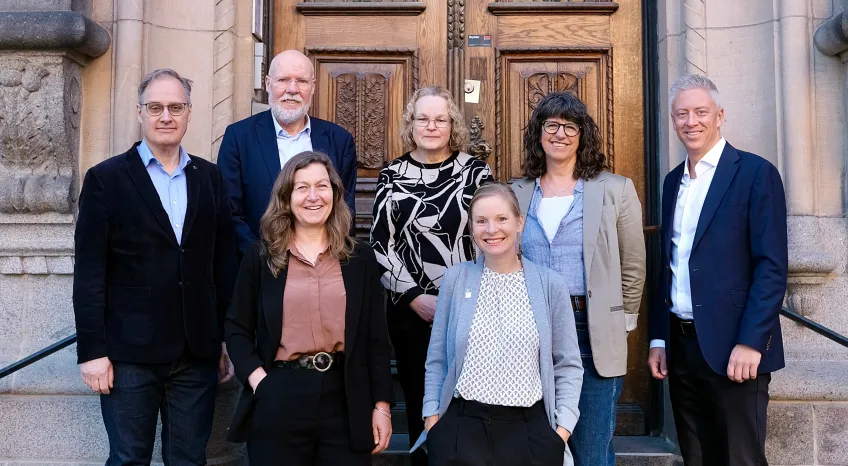 Seven persons in front of a door